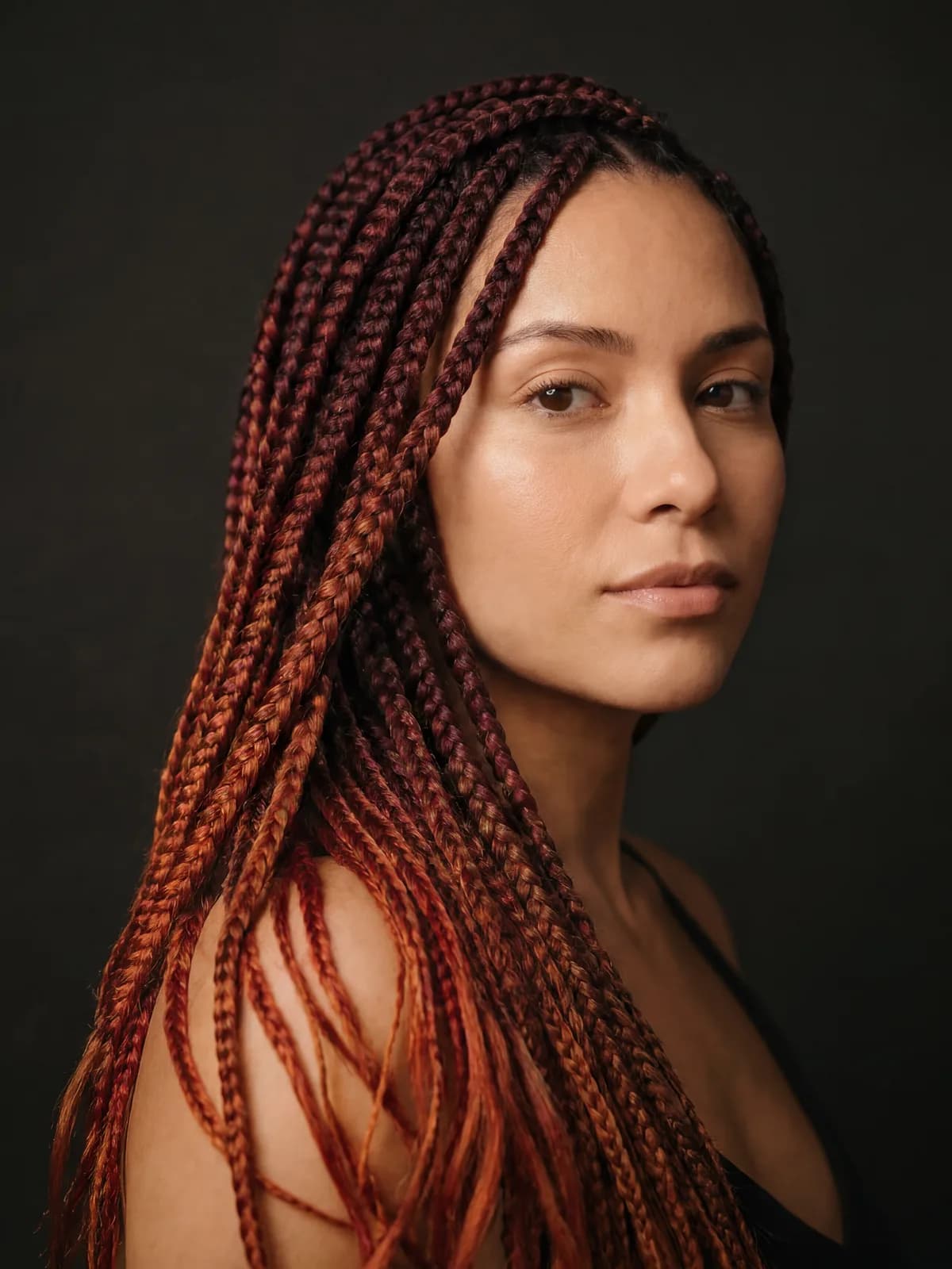 Mujer con box braids largas en degradado rojo borgoña a cobre, trabajo de Etnia Braids — estudio en Corona, Queens