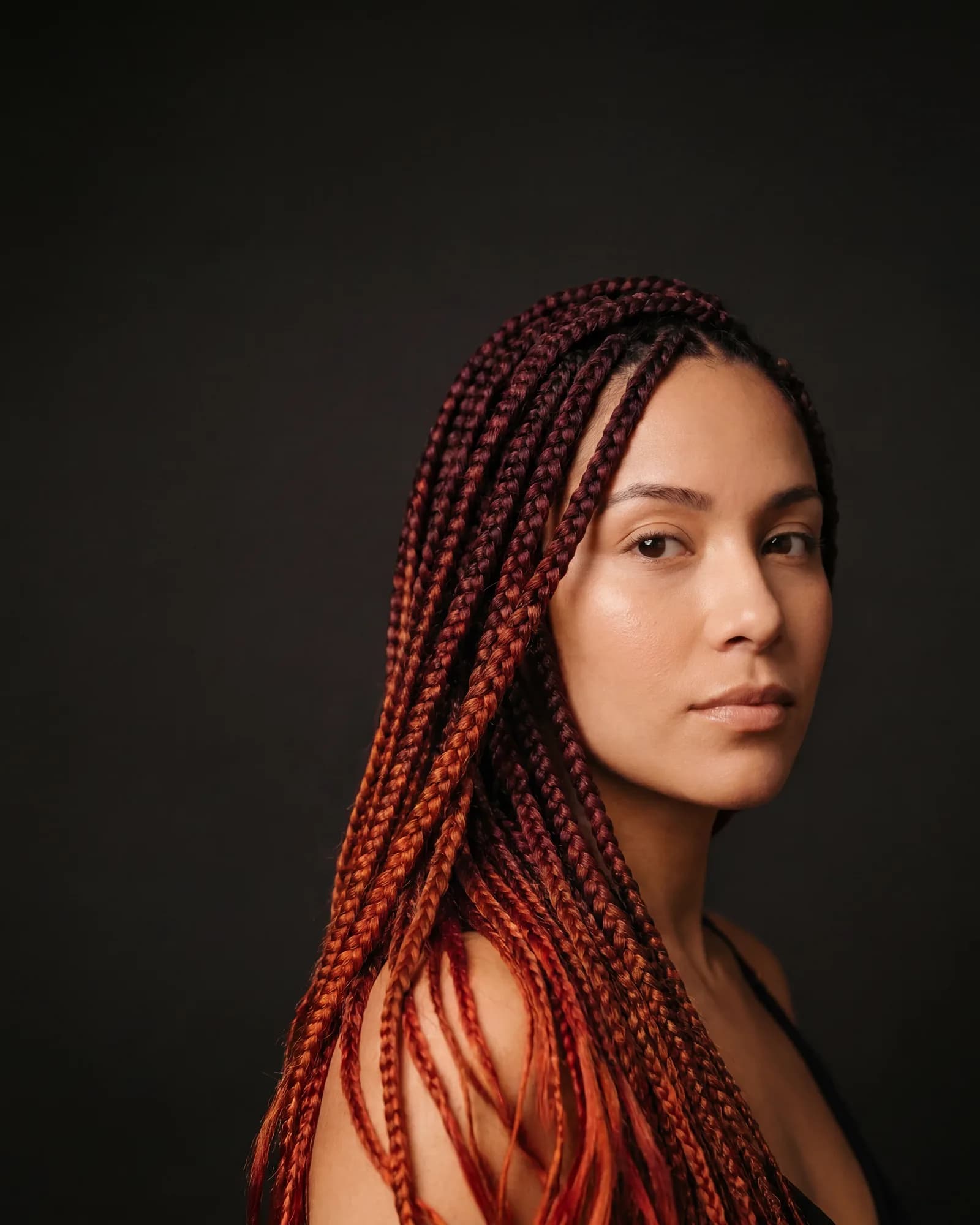 Mujer con box braids largas en degradado rojo borgoña a cobre, trabajo de Etnia Braids — estudio en Corona, Queens